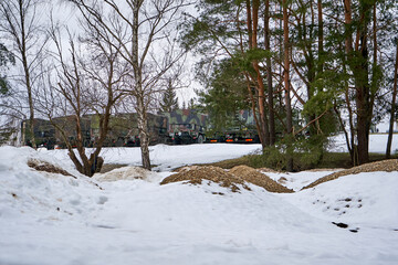 Military territory with camouflage trucks in the background