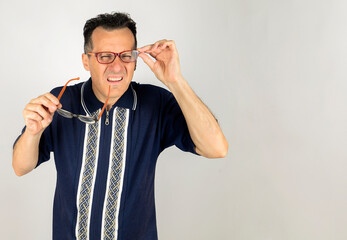 Nerd guy trying two pair of glasses to focus far away. White background and Copy Space.
