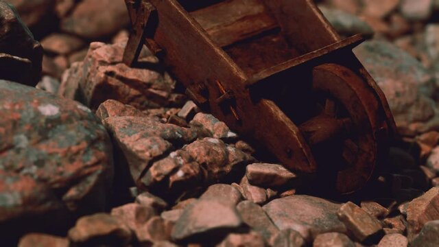 abandoned wooden mine wheelbarrow on rocks