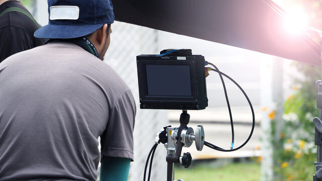 Video production at outdoor. Behind the scenes of outdoor video production working. Professional film crew team setting camera for recording movie. VDO camera with monitor for review.