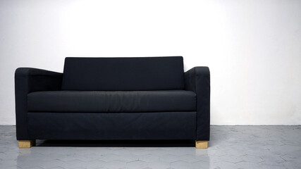 Modern sofa on white background. Black color sofa made from wood and fabric in white room. A bit old and dirty sofa chair.
