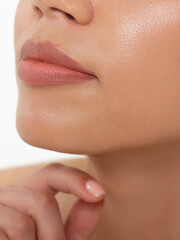 Cosmetics, makeup and trends. Bright lip gloss and lipstick on lips. Closeup of beautiful female mouth with natural lip makeup. Beautiful part of female face. Perfect clean skin in natural light