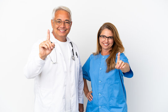 Middle age doctor and nurse isolated on white background showing and lifting a finger