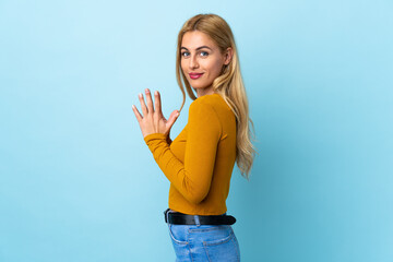 Young Uruguayan blonde woman over isolated blue background scheming something