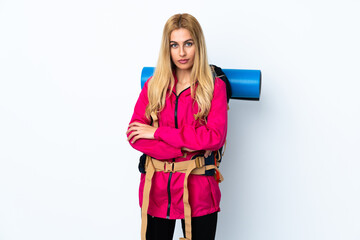 Young mountaineer woman with a big backpack over isolated white background keeping arms crossed