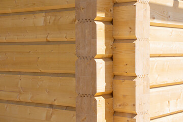 Fragment of a construction built of glued pine timber beams.