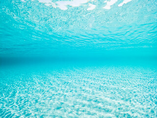 Fototapeta na wymiar (Selective focus) Stunning underwater view of a turquoise and transparent sea with white sand. La Maddalena Archipelago, Sardinia, Italy. Natural background with copy space.