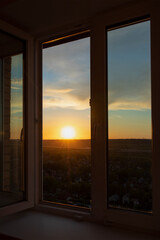 Sunset view from the window of a high-rise building on the outskirts of a megalopolis in Russia.
