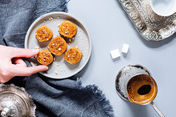 Bosnian and Turkish dessert called Ruzica served on a grey background with cup of coffee
