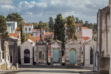 Fototapeta na wymiar The beautiful architecture of the Prazeres Cemetery in the city of Lisbon, with its tombs of imposing buildings.