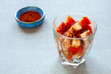Fresh fruit dessert with chili and cacao powder spice mix. Fresh raw sweet cut watermelon and melon in glass. Summer snack.