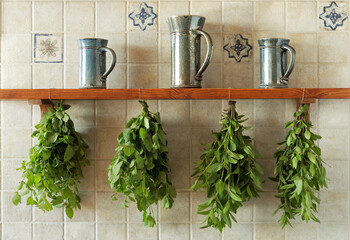 Fresh herbs drying on kitchen shelf. Mint and lemon balm herb in bunches upside down.