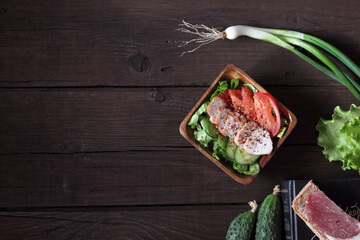Salad with chicken meat. Salad of fresh vegetables with chicken breast. Meat salad with chicken fillet and fresh vegetables on a plate on a wooden background