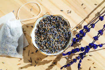 Dried lavender and tea bag sachet on wooden table. Organic flower herbal drink. Zero waste wrapper.