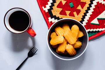 Bosnian and Turkish dessert called Tulumba served on a grey background with cup of coffee