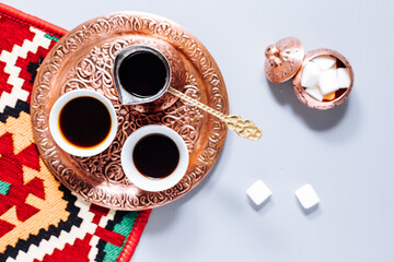 Top view of Turkish or Bosnian coffee with three sugar cubes and traditional carpet