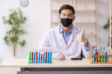 Young male chemist working at the lab during pandemic