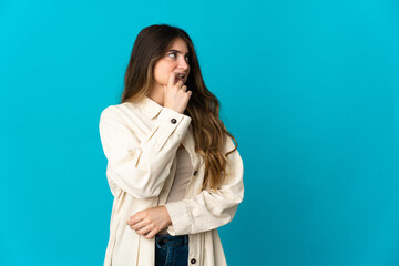 Young caucasian woman isolated on blue background nervous and scared