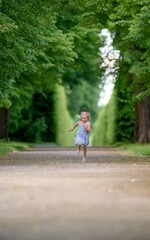 Little blond girl in the park portrait.