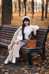 Picture of beautiful woman goes for a walk to the autumn park