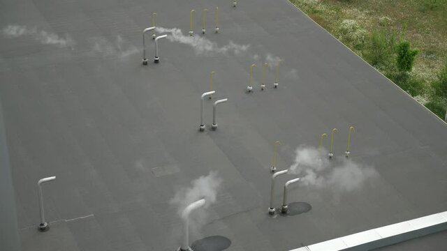 Small curved tubes with fuming smoke on the roof of a soy bean oil plant 