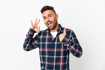 Naklejka premium Caucasian man isolated on white background showing ok sign and thumb up gesture