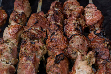 Grilled skewers of meat on the coals, with smoke. street food.