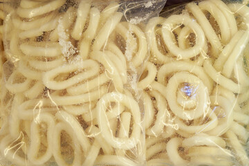Frozen squid rings. Freezer with seafood in the fish market.