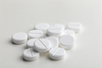 a handful of round white pills on a white table close-up, macro, medical background