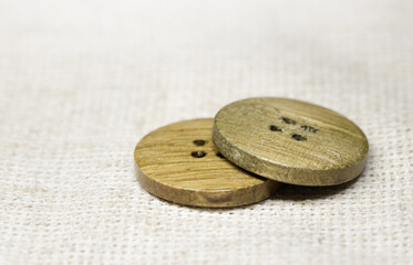 two wooden buttons lie on burlap, side view, close-up .selective focus.High quality photo