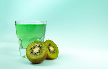 Sweet dessert, kiwi jelly in glass glasses and next to fresh kiwi cut into two halves on mint background copy space
