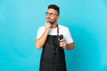 Barber man in an apron having doubts while looking up
