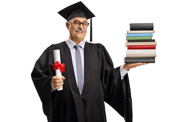 Mature man in a graduation gown holding a diploma and a pile of books