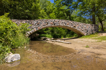 Stone Arch Footbridge Over A Creek