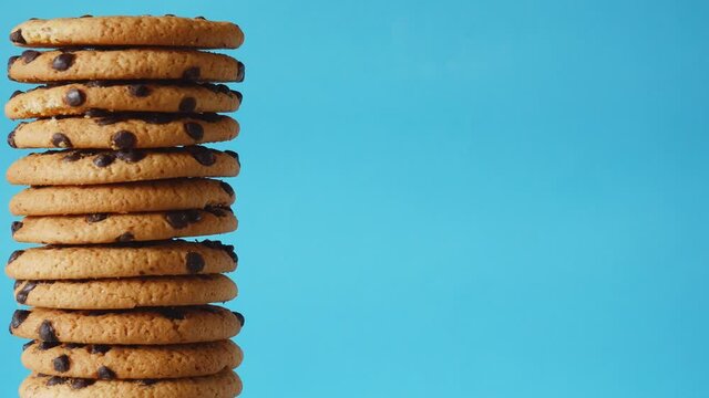 A stack chocolate chip cookies rotate on a blue background. American cookies close up.place for text