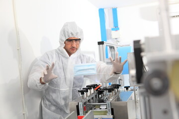 Naklejka premium Production engineer with face mask working in factory , Qc engineer checking mask for good quality , Concept of protective action and quarantine to stop spreading of Coronavirus Disease 2019