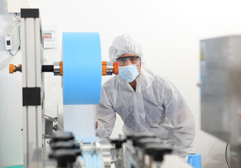 Naklejka premium Production engineer with face mask working in factory , Qc engineer checking mask for good quality , Concept of protective action and quarantine to stop spreading of Coronavirus Disease 2019