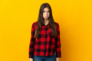 Teenager Brazilian girl isolated on yellow background with sad expression
