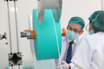 Fototapeta premium Production engineer with face mask working in factory , Qc engineer checking mask for good quality , Concept of protective action and quarantine to stop spreading of Coronavirus Disease 2019 