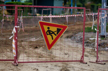Roadworks sign on a temporary fence.