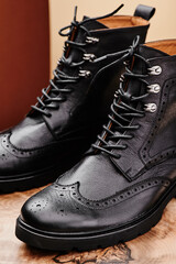 Black leather women's boots made of genuine leather in a classic style on a wooden cut. Close-up. . High quality photo
