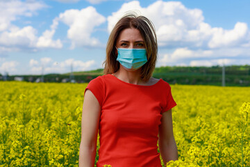 Young pretty woman in a colored dress on Lightning cheerful yellow background blooming rapeseed...