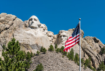 American flag waiving in front of Mount Rushmore - obrazy, fototapety, plakaty
