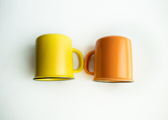 Obraz na płótnie Canvas Ceramic mug Yellow and orange on a white background,Placement