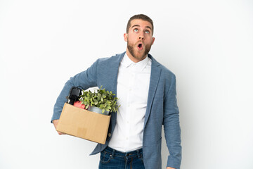 Young caucasian making a move while picking up a box full of things isolated on white background...