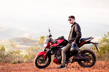 Obraz na płótnie Canvas Young man riding his motorbike and enjoying the road trip. travel concept