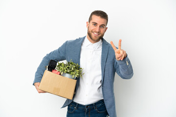 Young caucasian making a move while picking up a box full of things isolated on white background...