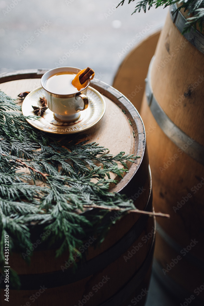 Wall mural hot toddy tea cup on whiskey barrel with greenery 