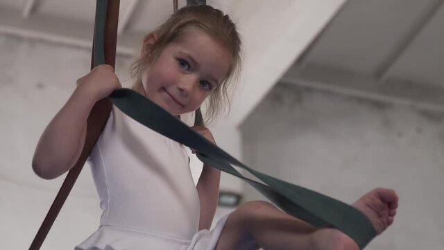 Portrait of a little girl doing aerial silks in the gym, healthy lifestyle
