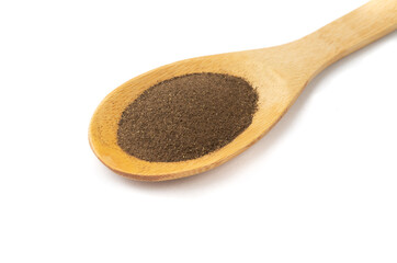 Closeup of ground black pepper on a wooden spoon isolated over white background